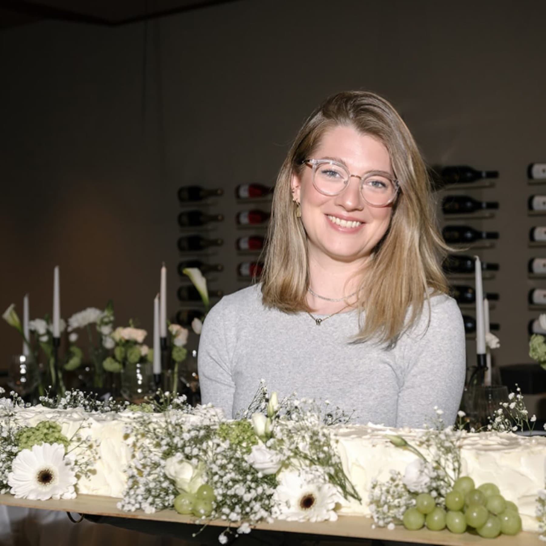 Kerstin Ederer präsentiert einen langen Sweet Table mit Blüten und Trauben